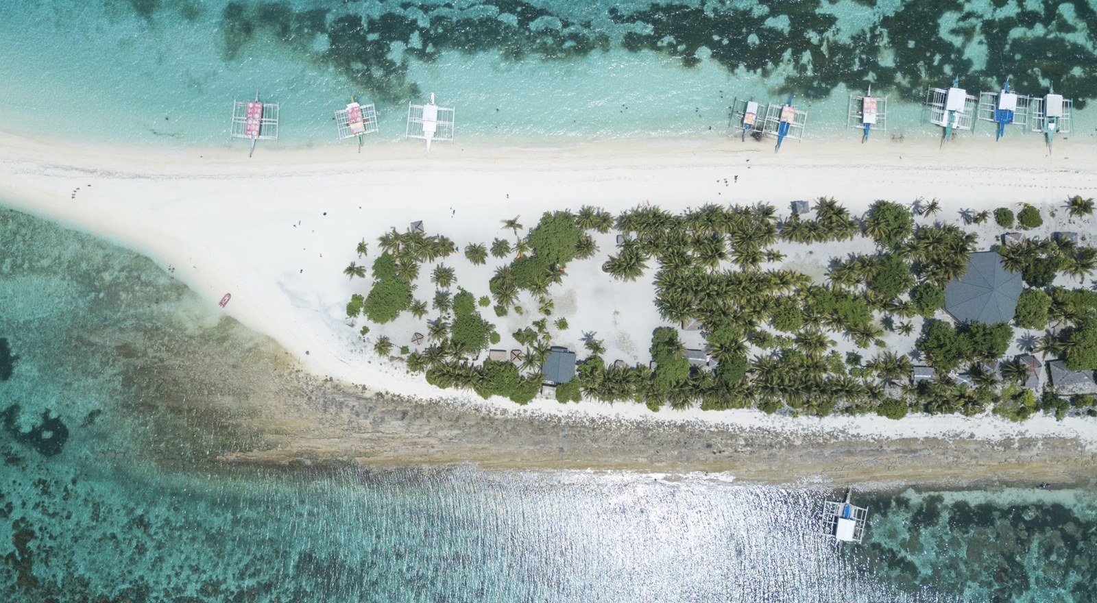 Overhead aerial vista of uninhabited island beaches fringed with coconut palms