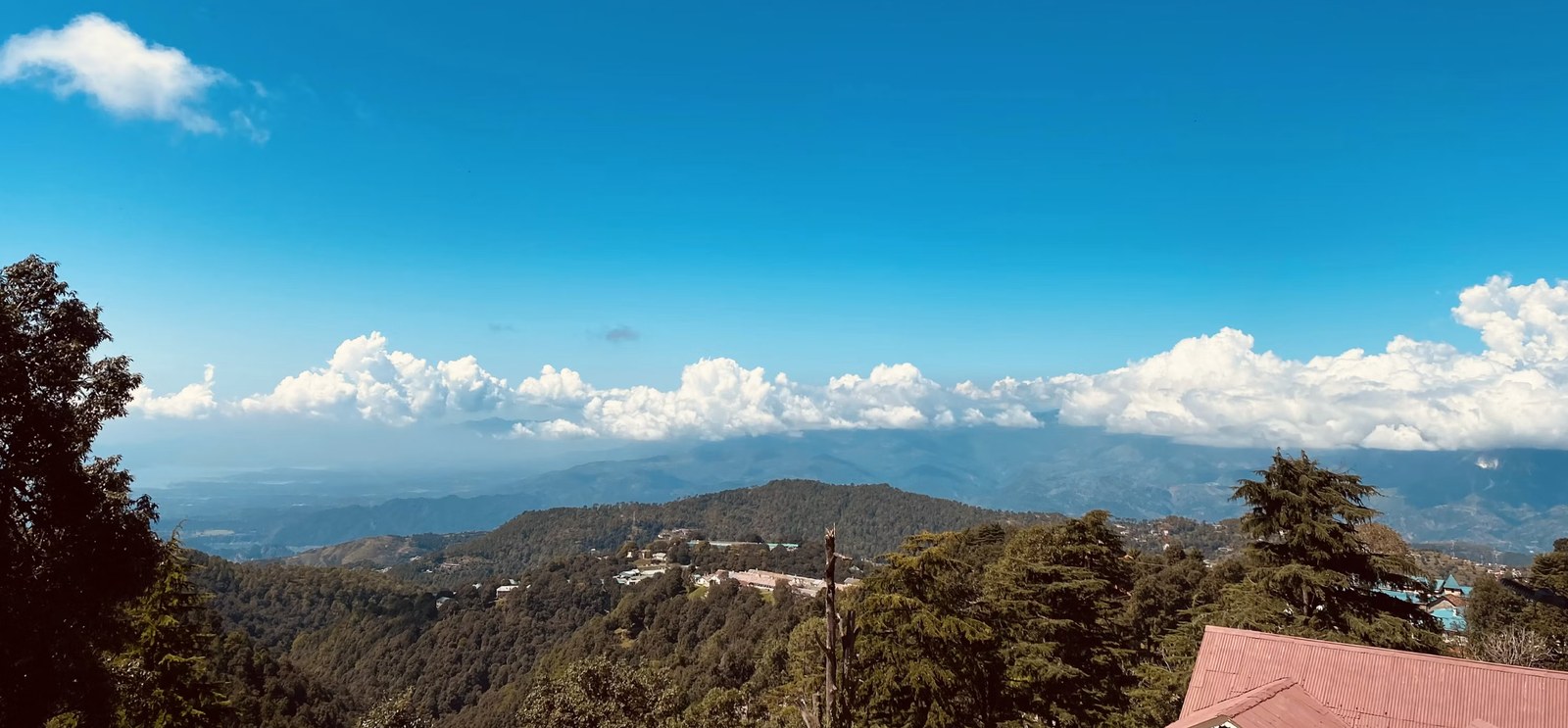 Panoramic snow-covered Dhauladhar mountain range under brilliant blue skies