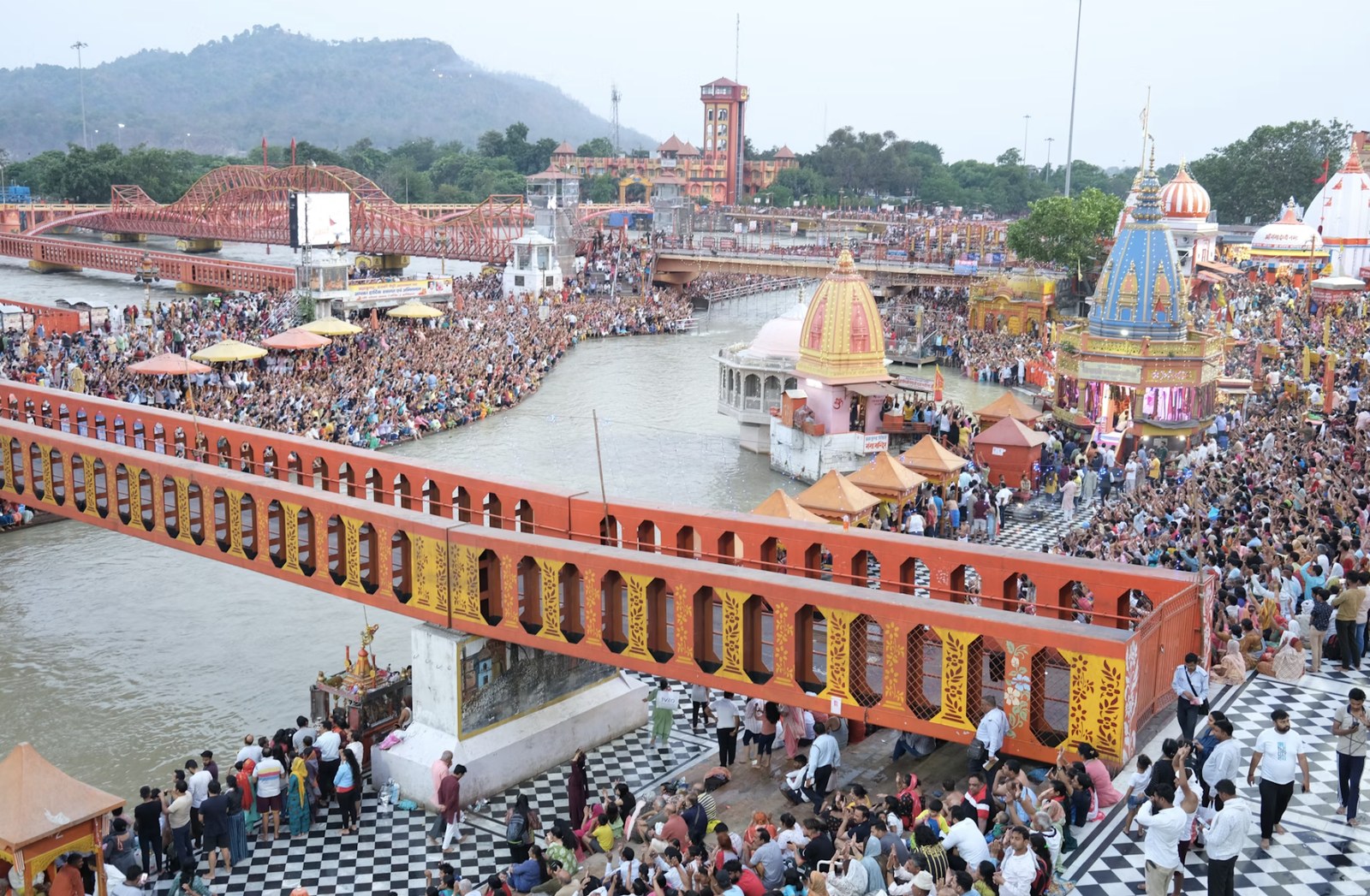 Bustling pedestrian bridge and gathering of pilgrims at Har Ki Pauri