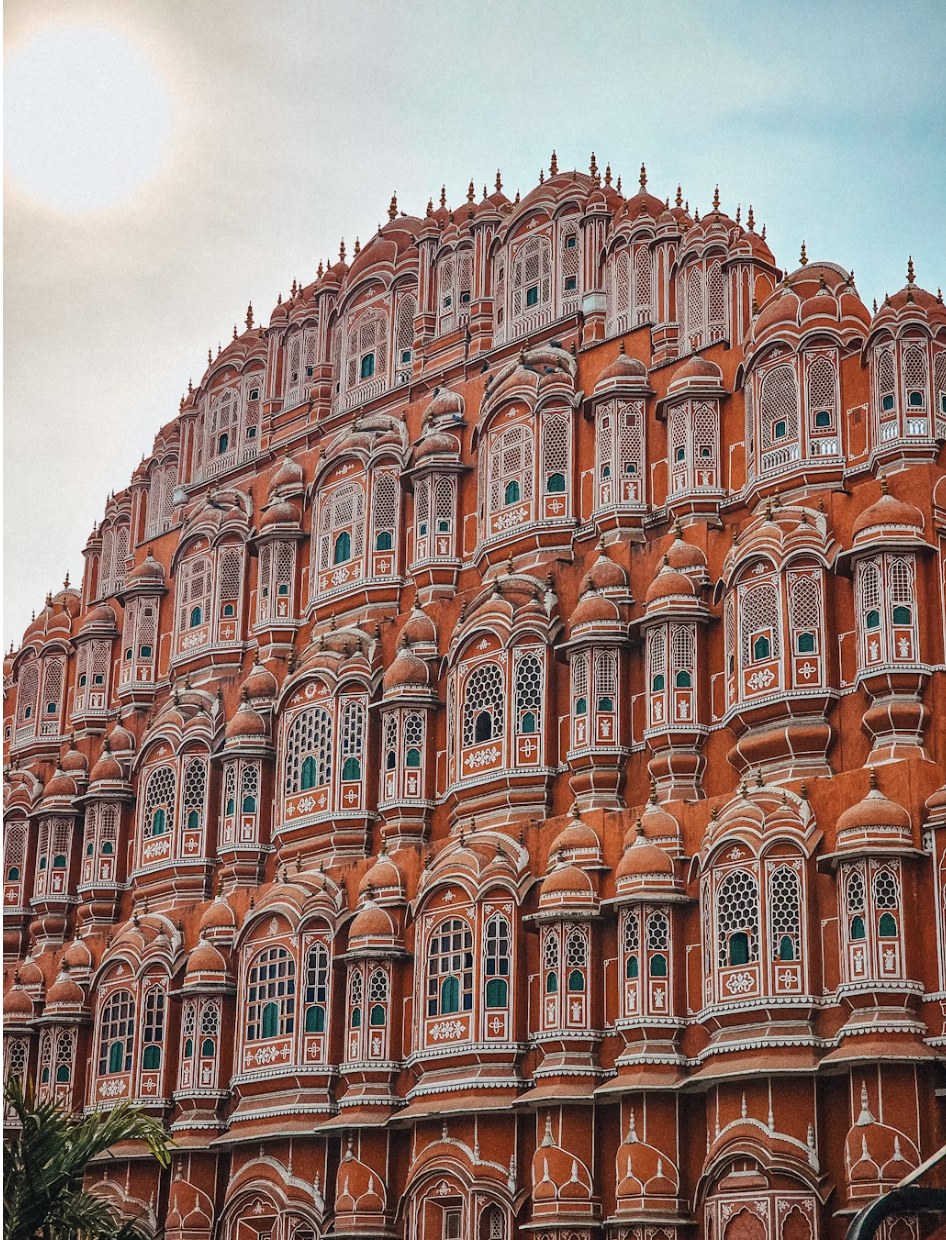 Intricate sandstone jharokhas and latticed windows of Hawa Mahal against the sky