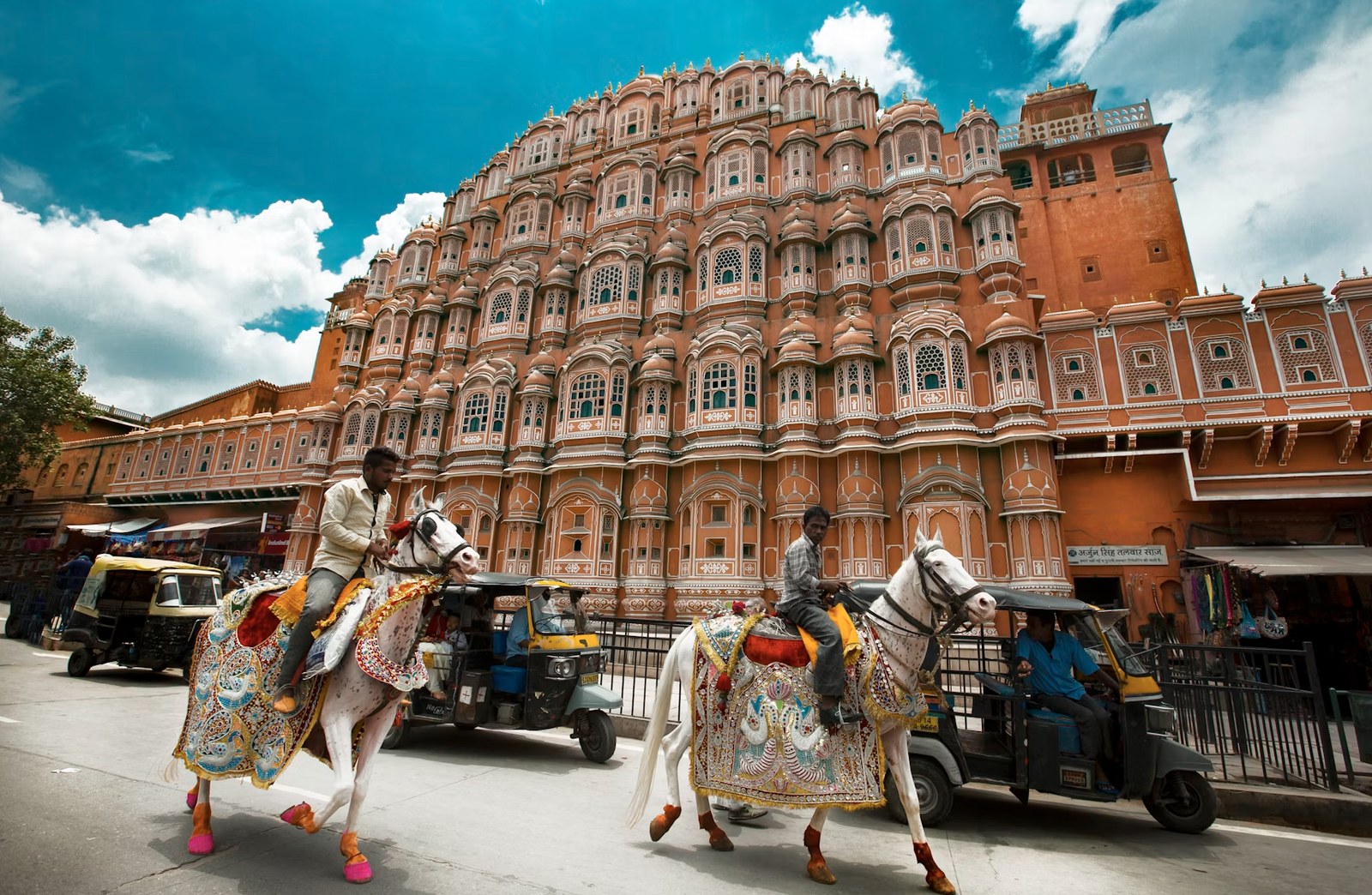 Iconic five-story facade of Hawa Mahal with traditional royal carriages