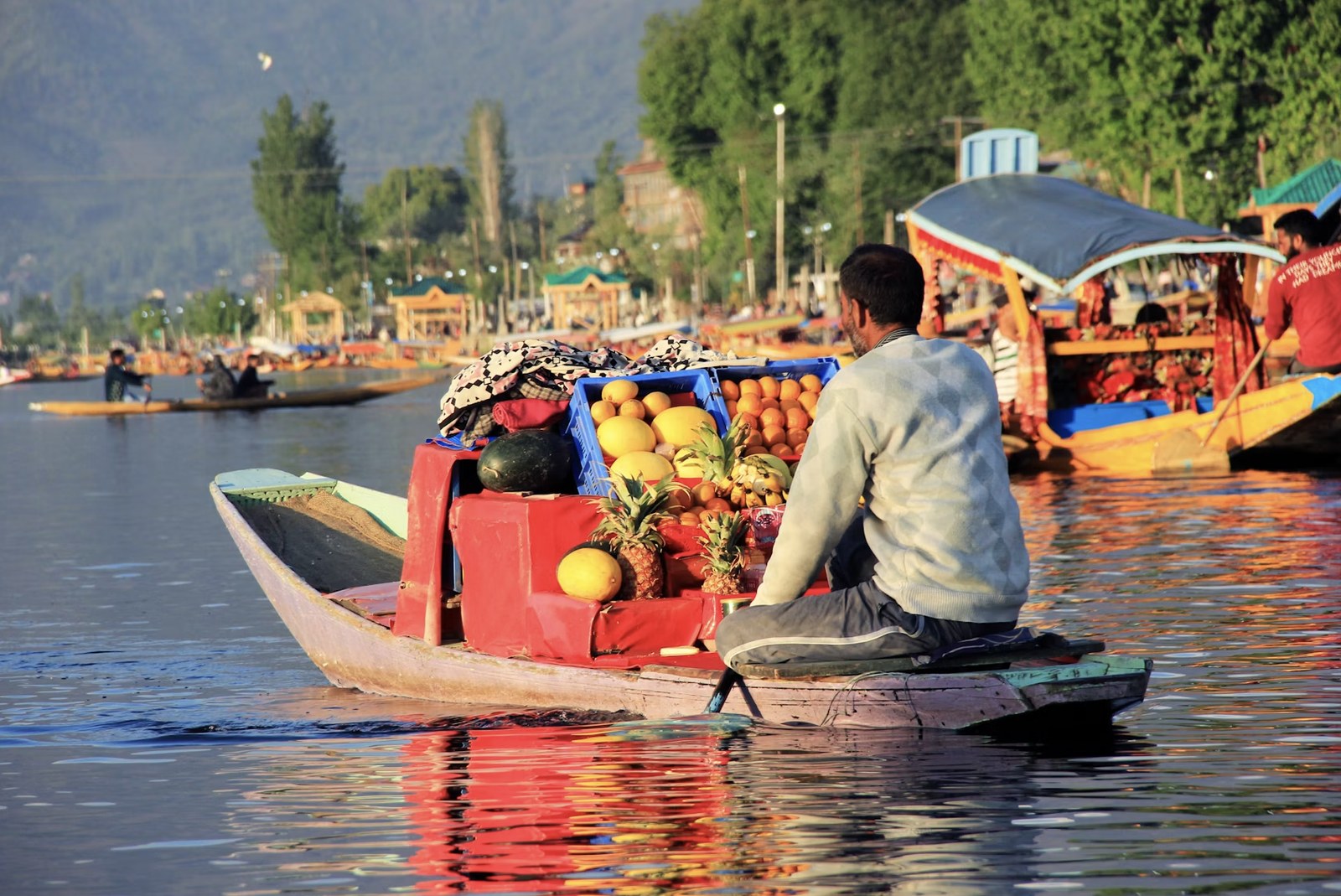 Traditional Kashmiri boatman rowing a decorated wooden Shikara