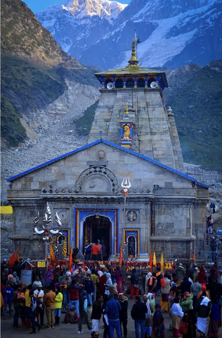 Kedarnath Temple glowing at dusk with evening aarti and gathering pilgrims