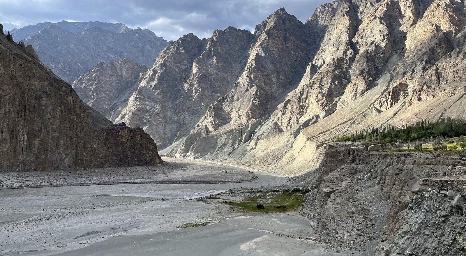 Expansive cold desert riverbed surrounded by towering barren peaks