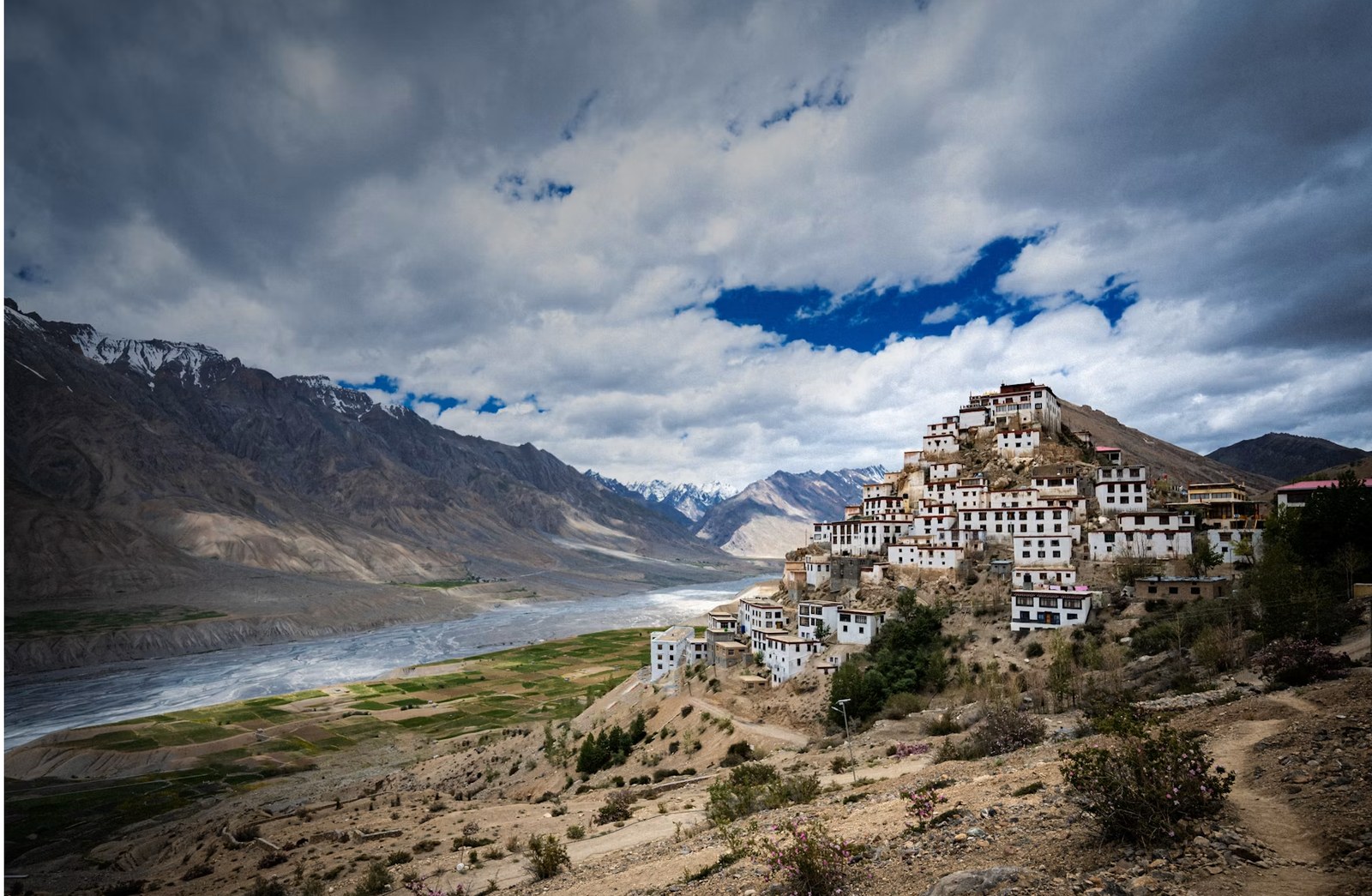 Ancient Tibetan Buddhist monastery perched atop dramatic mountain ridge