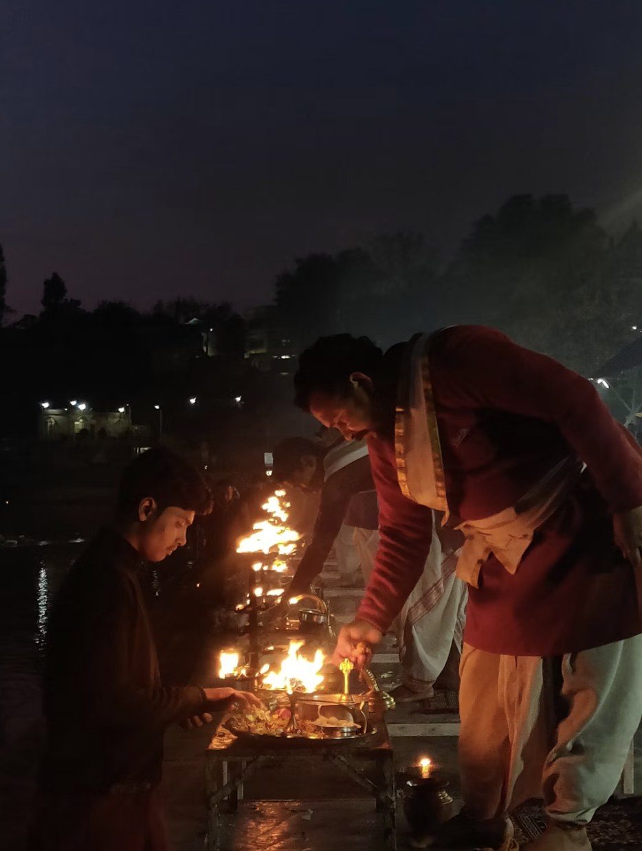 Devotees participating in the divine evening Ganga Aarti ceremony with brass lamps