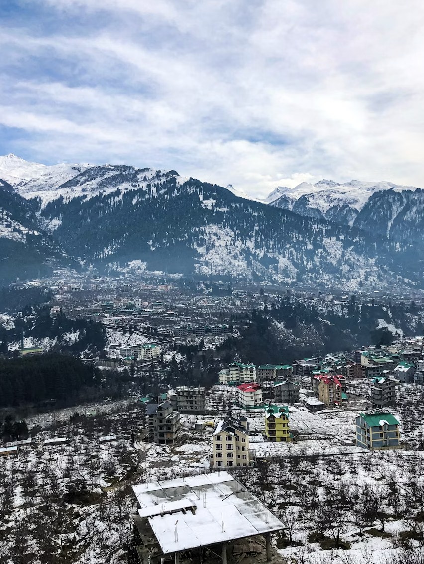 Manali town and snowy Pir Panjal mountain ranges under winter skies