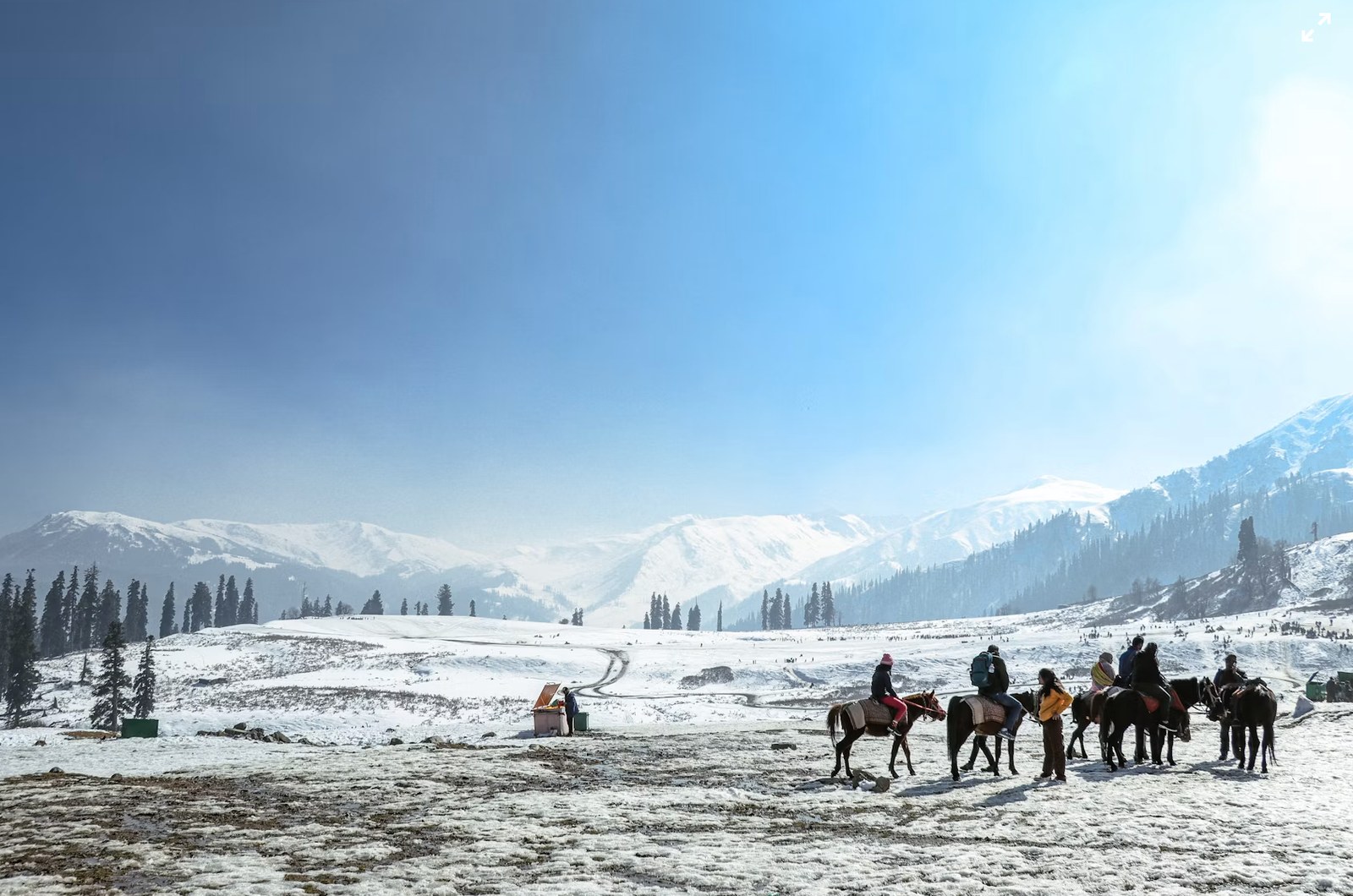 Snow-covered meadows of Gulmarg with horseback riders