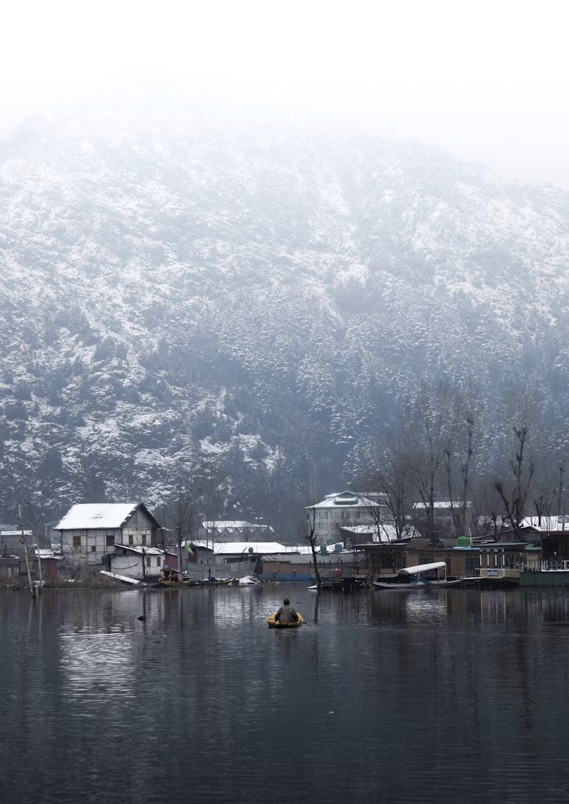 Misty snow-draped lakeside settlement and winter landscape