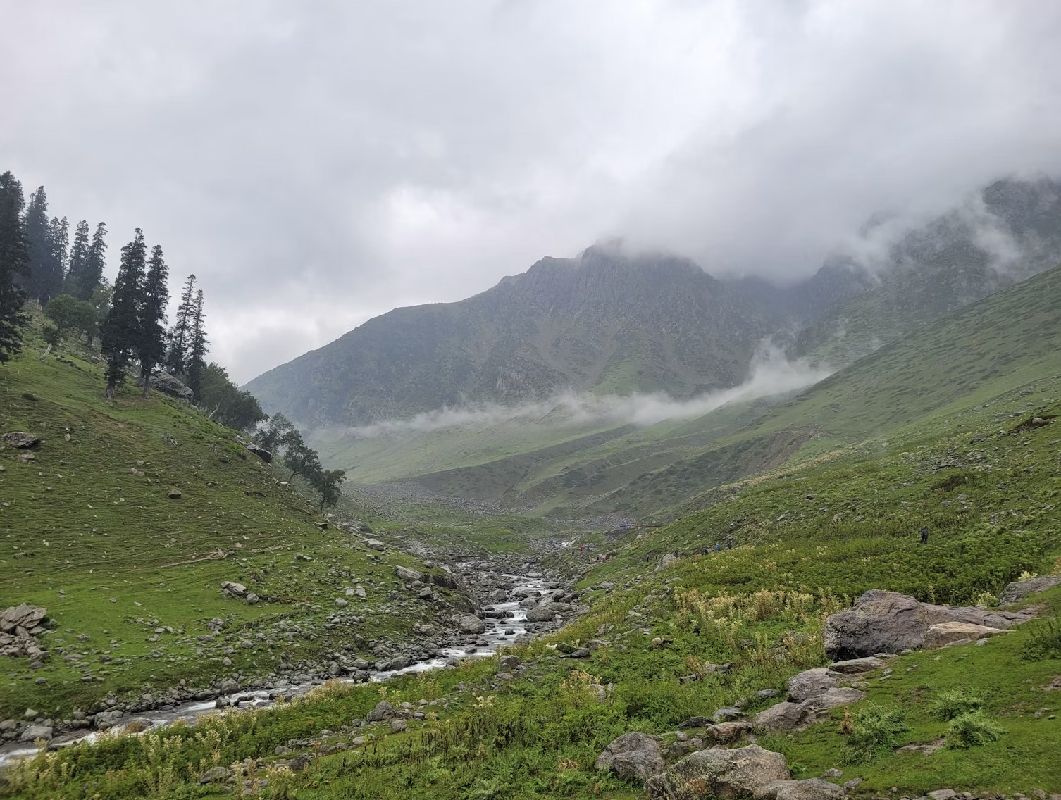Misty mountain river stream winding through rolling green hills