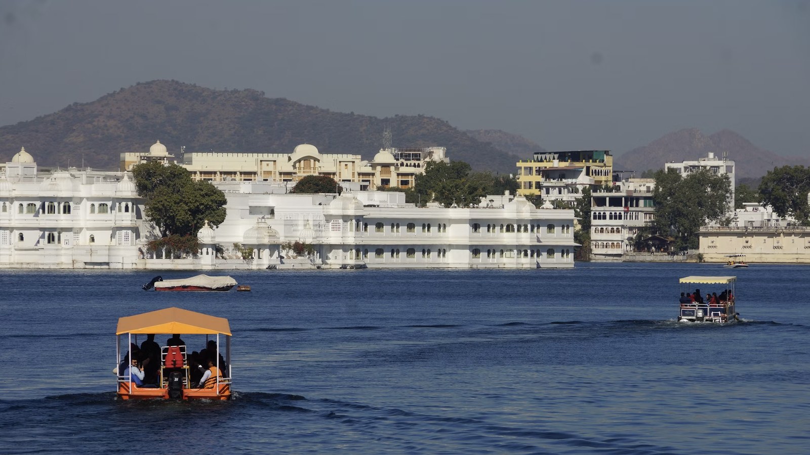 Romantic boat ride cruising past the iconic marble Taj Lake Palace
