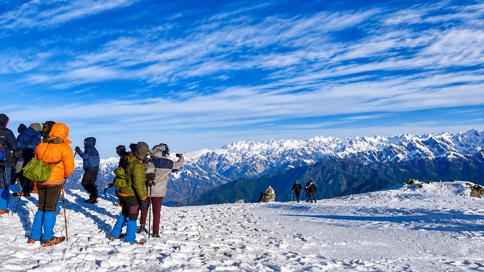 Celebrations at Kedarkantha summit overlooking Himalayan mountain ranges