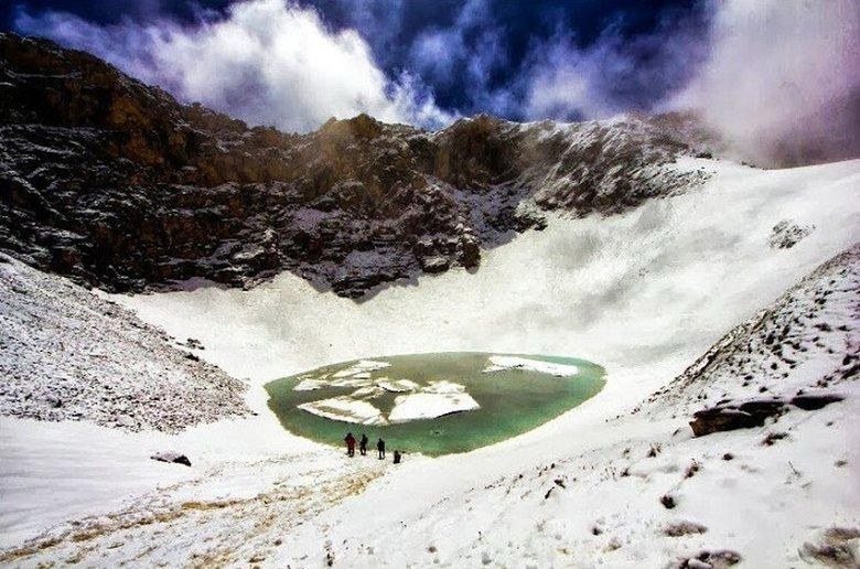 Close-up perspective of the glacial lake waters and surrounding snow amphitheatre