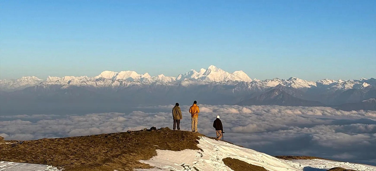 Trekkers taking in the vast sea of clouds and mountain horizons