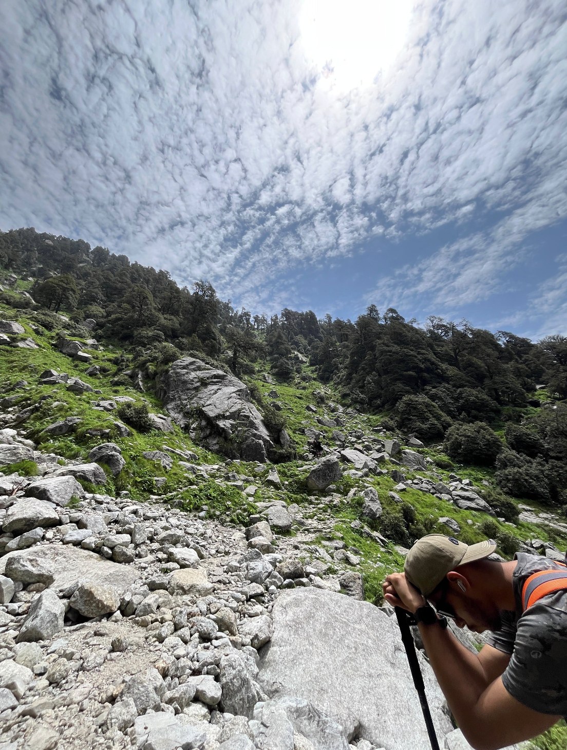 Trekker navigating the rocky forest trail to Triund